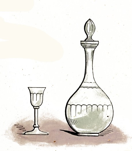 A wine glass beside a clear glass decanter